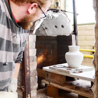 A pot in front of a kiln.