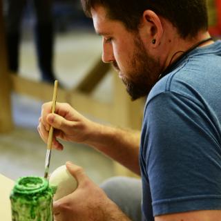 A man painting pottery.
