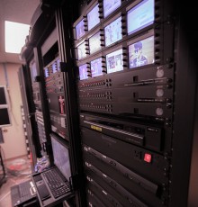 Rack of headend technology streaming encoders and preview monitor displays.