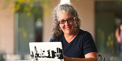 A woman using a laptop outside.