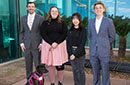 Four students and a dog posing outdoors on the MCC campus