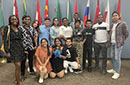 A group of students posing in front of various international flags