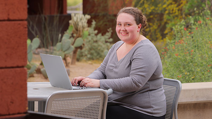 A student working on a laptop outside at the Red Mountain campus