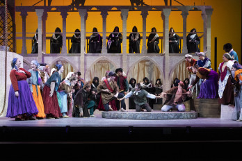 Men and women in medieval costumes on stage.