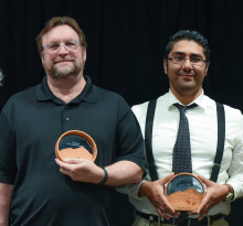 Two people holding awards