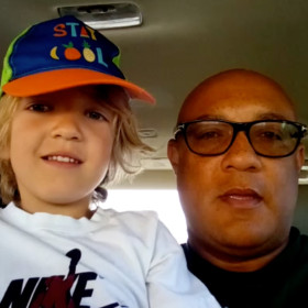 Jason Carter and his son wearing a baseball cap